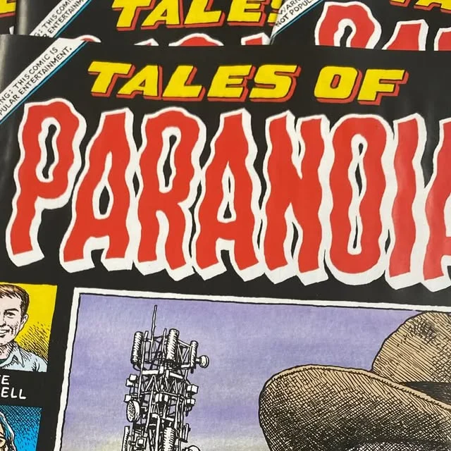 Stack of independent comics with red and yellow Tales of Paranoia cover lettering